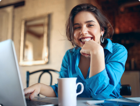 Mulher sorrindo usando um laptop.